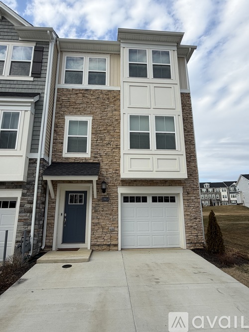 A two-story house with a garage door and a front door.