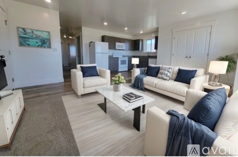 A living room with white furniture and a grey rug.