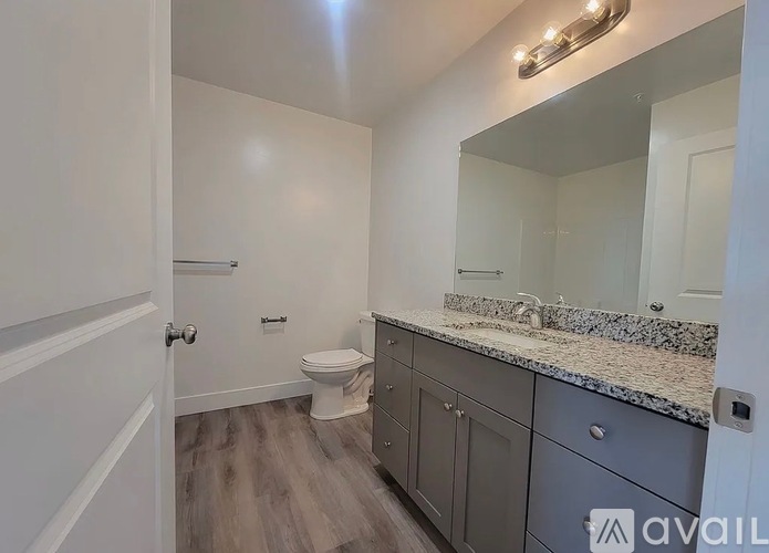 A bathroom with a toilet, sink, and vanity.