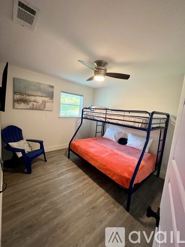 A bedroom with a bunk bed and a chair.