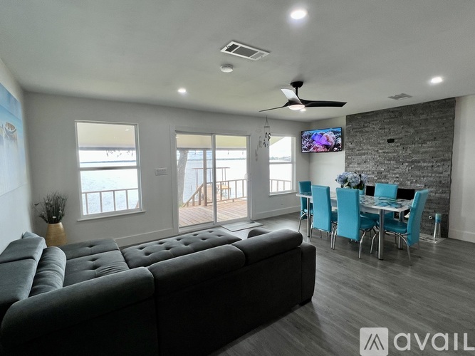 A living room with a grey sofa and a television mounted on the wall.