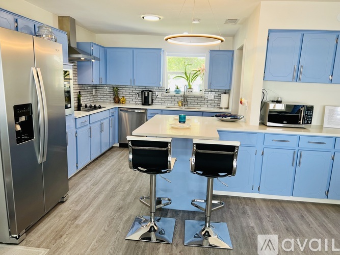 A kitchen with blue cabinets and a white island.