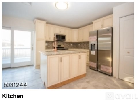 A kitchen with a refrigerator and a microwave.