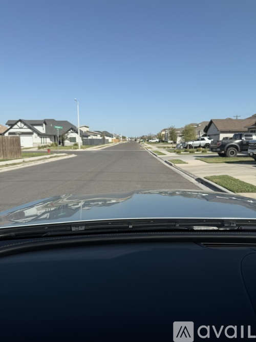 A car is driving down a quiet residential street.