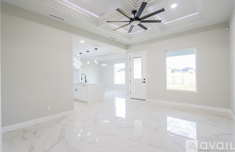 A spacious room with a marble floor and a ceiling fan.