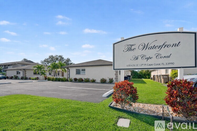 A sign for The Waterfront at Cape Coral in front of a building.