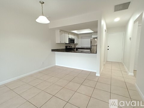 A kitchen area with a counter and cabinets is visible.