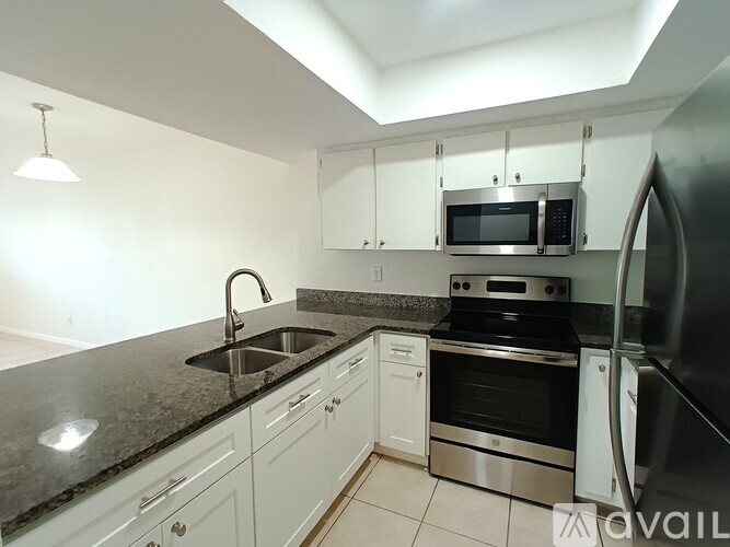 A kitchen with a black counter top and white cabinets.