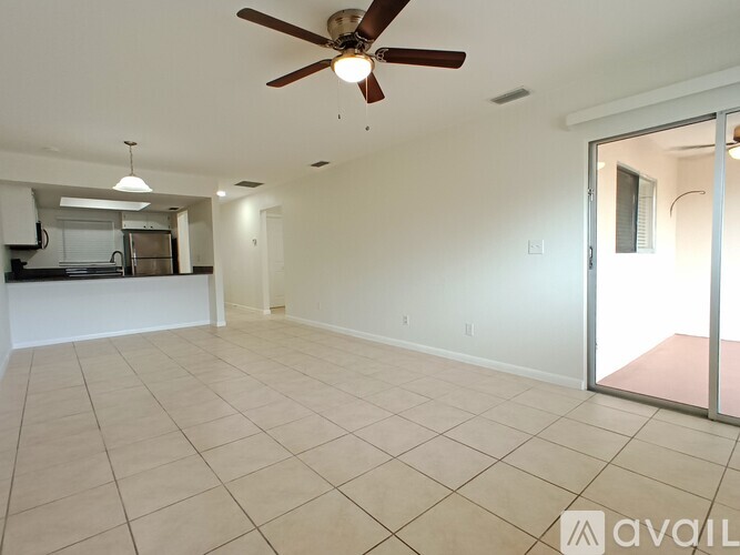 A spacious room with a ceiling fan and sliding glass doors.