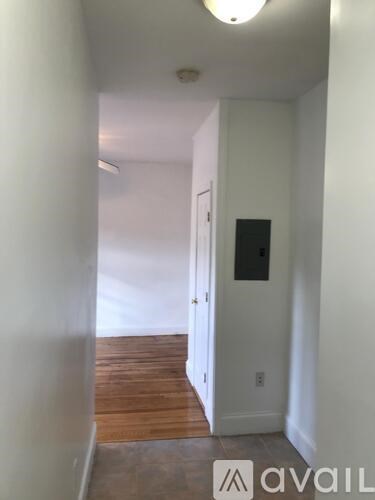 A hallway with a door and a light on the ceiling.