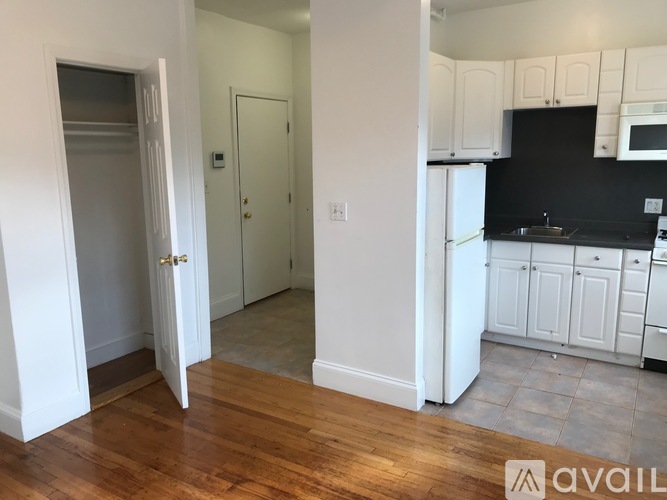 A kitchen with white cabinets and a black countertop.