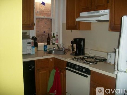 A kitchen with a white fridge, white oven, and a black coffee maker.