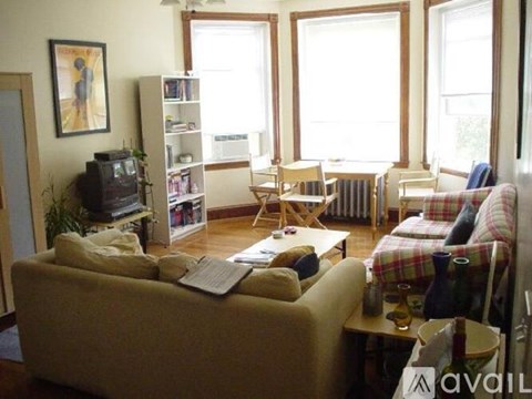 A living room with a couch, chair, and television.
