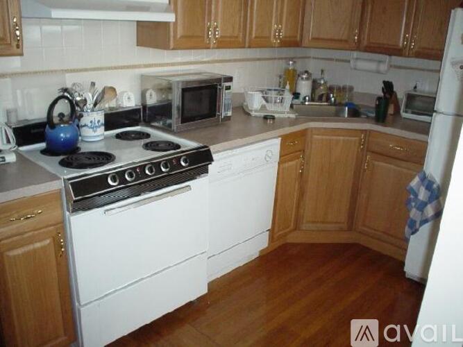 A kitchen with a white stove top oven and white refrigerator.