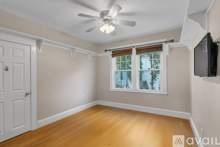 A room with a ceiling fan and a window with blinds.