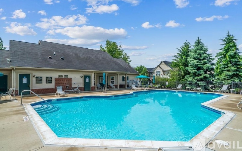 A large swimming pool in front of a building with trees around.