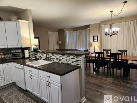 A kitchen with white cabinets and a black countertop.