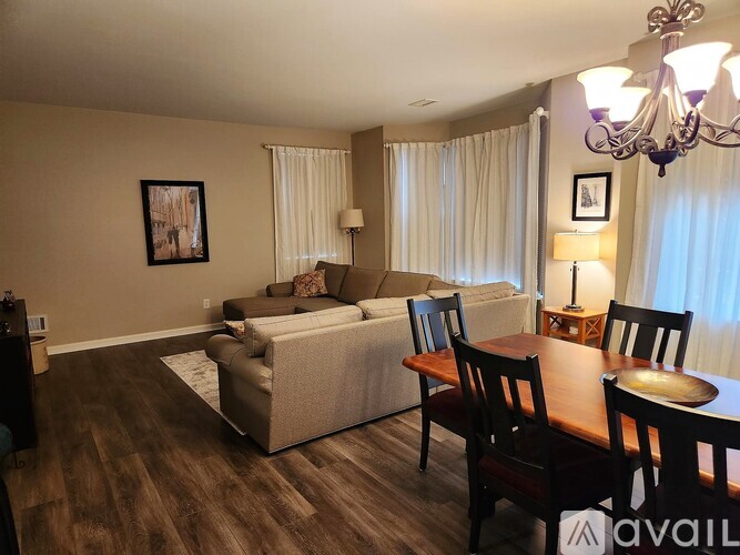 A living room with a couch, a bed, a table, and chairs.