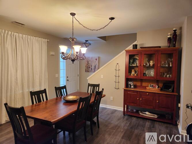 A dining room with a wooden table and chairs.