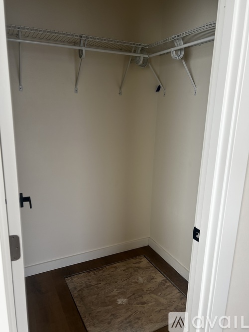 A white closet with a white door and a white shelf.