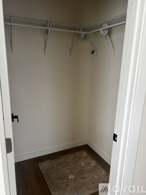 A white closet with a white door and a white shelf.