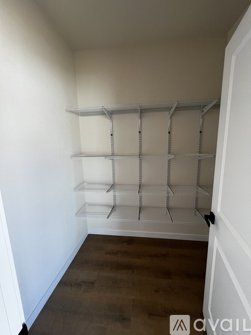 Empty white shelves in a room with wooden flooring.