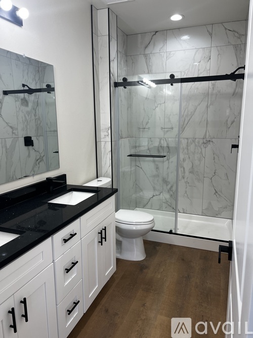 A bathroom with a marble wall and a white toilet.