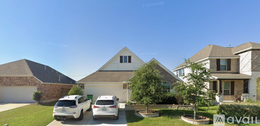 Two white cars are parked in front of a house.