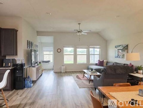 A living room with a grey couch and a dining table.