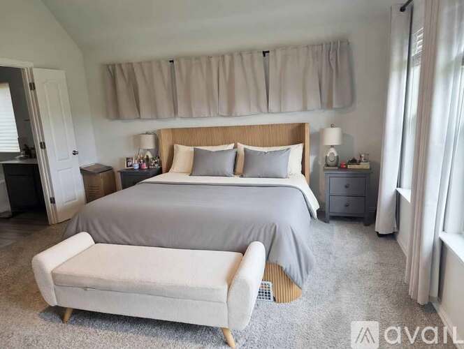 A bedroom with a large bed and a bench.