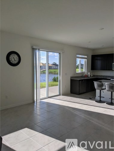A kitchen with a bar stool and a clock on the wall.