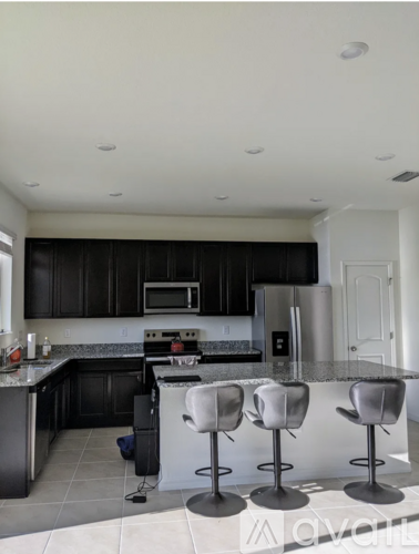 A kitchen with black cabinets and white appliances.