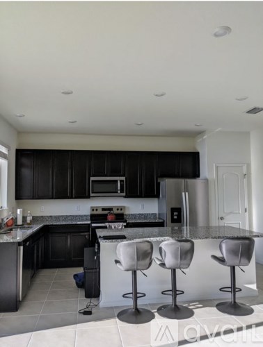 A kitchen with black cabinets and white appliances.