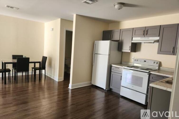 A kitchen with white appliances and a dining table with chairs.