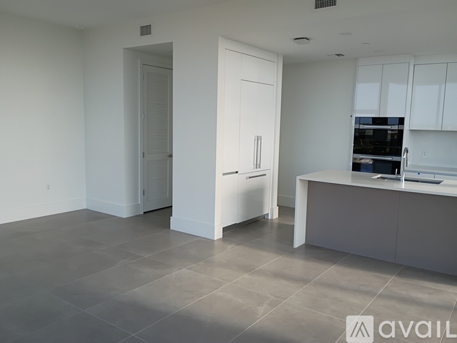 A spacious kitchen with white cabinets and a large island.