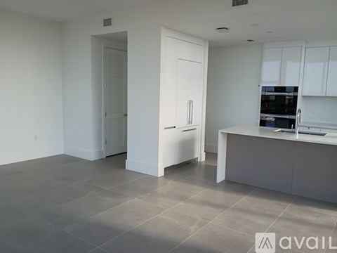 A spacious kitchen with white cabinets and a large island.