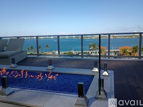 A pool with a view of the ocean and a bridge in the distance.