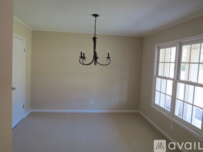 A room with a chandelier and a window.