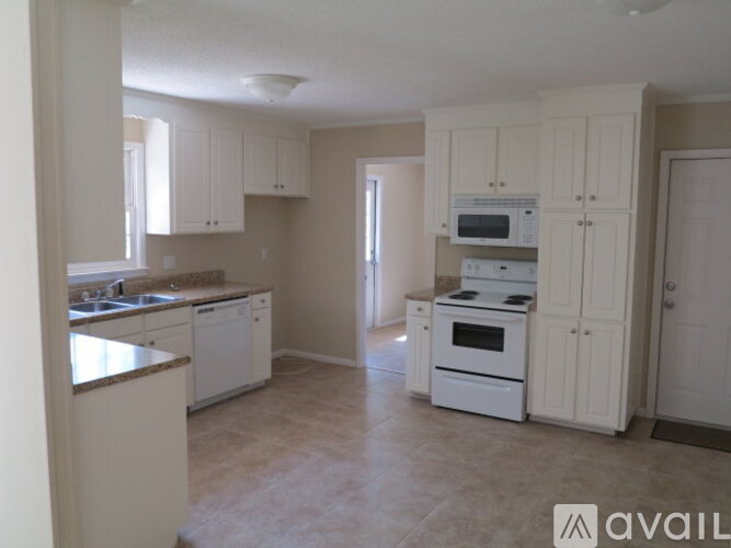A kitchen with white appliances and cabinets.