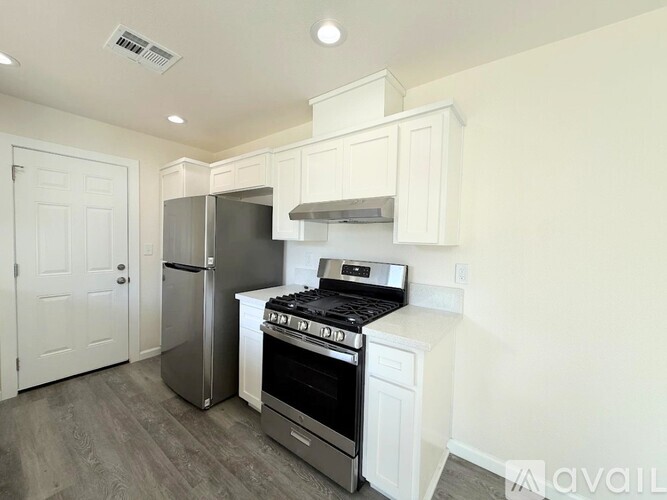 A kitchen with white cabinets and a black stove top oven.