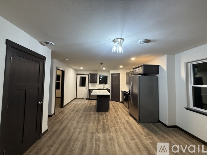 A spacious kitchen area with a refrigerator, sink, and cabinets.