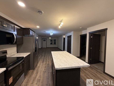 A kitchen with a long counter and a refrigerator.