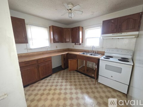 A kitchen with a white stove and brown cabinets.