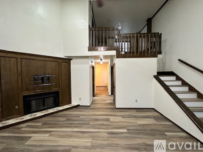 A living room with a fireplace and a staircase.