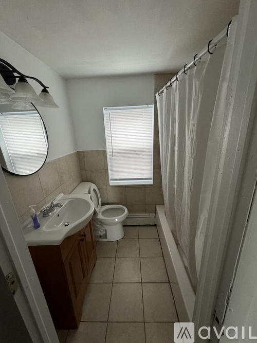 A bathroom with a toilet, sink, and shower.