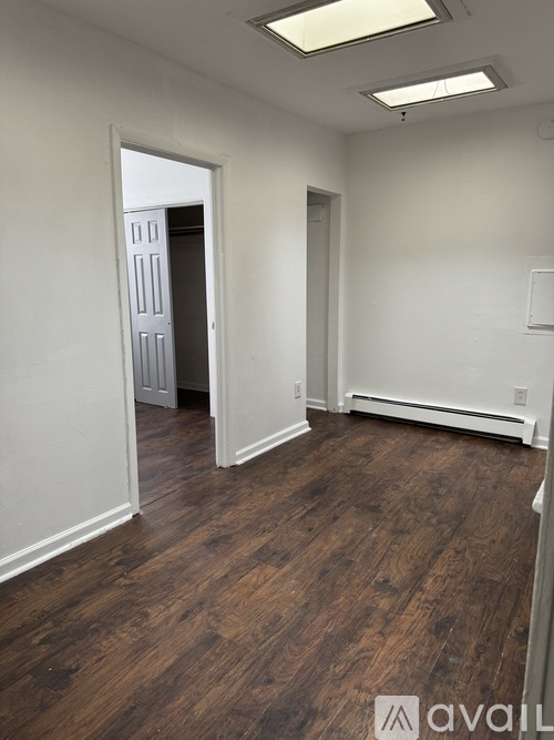 A room with wooden flooring and white walls.