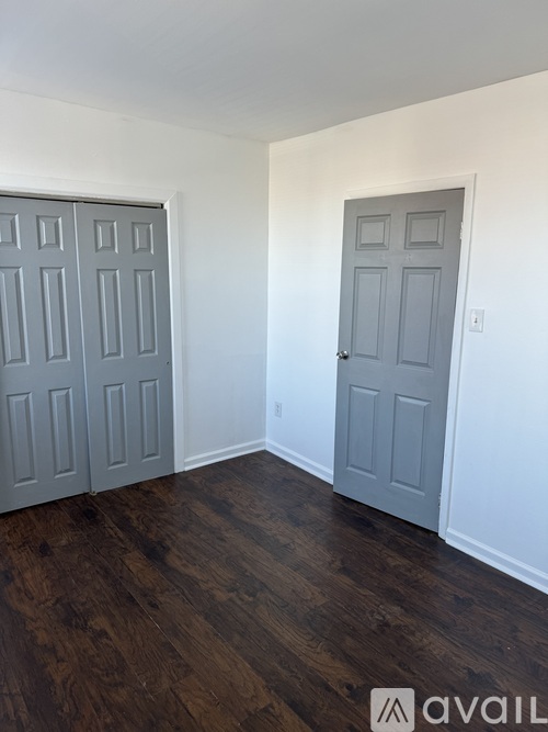 A room with two doors and wooden floors.