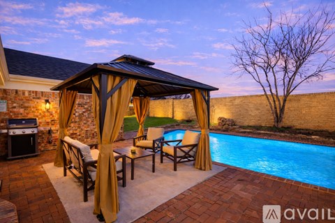 A poolside patio area with a gazebo and chairs.