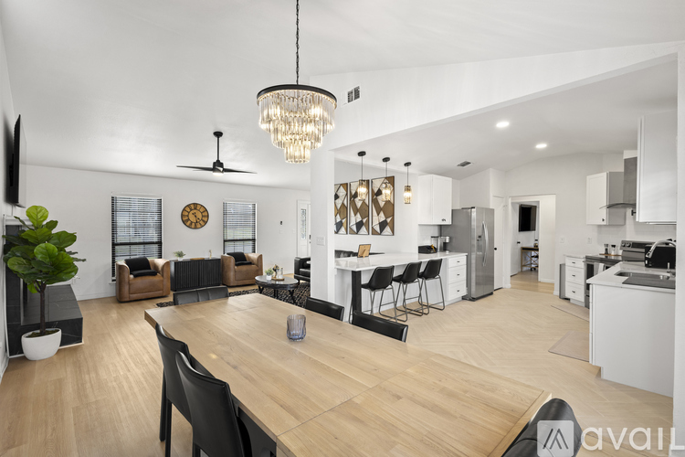 A modern open plan living and dining area with a wooden table and chairs.