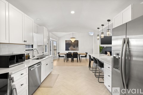 A modern kitchen with white cabinets and stainless steel appliances.